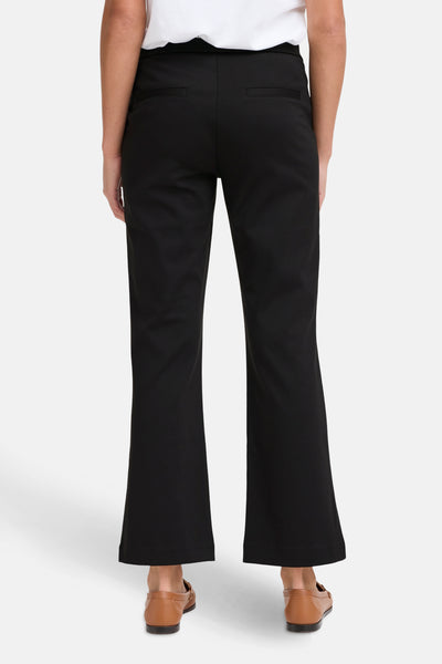 Pantalon noir de Fransa, coupe évasée et poches arrières passepoilées, porté avec des mocassins marrons.
