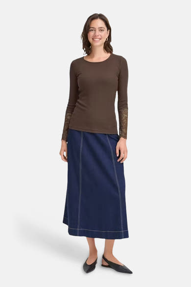 Brown long-sleeve t-shirt with lace cuffs, front view, worn with navy skirt and black flats