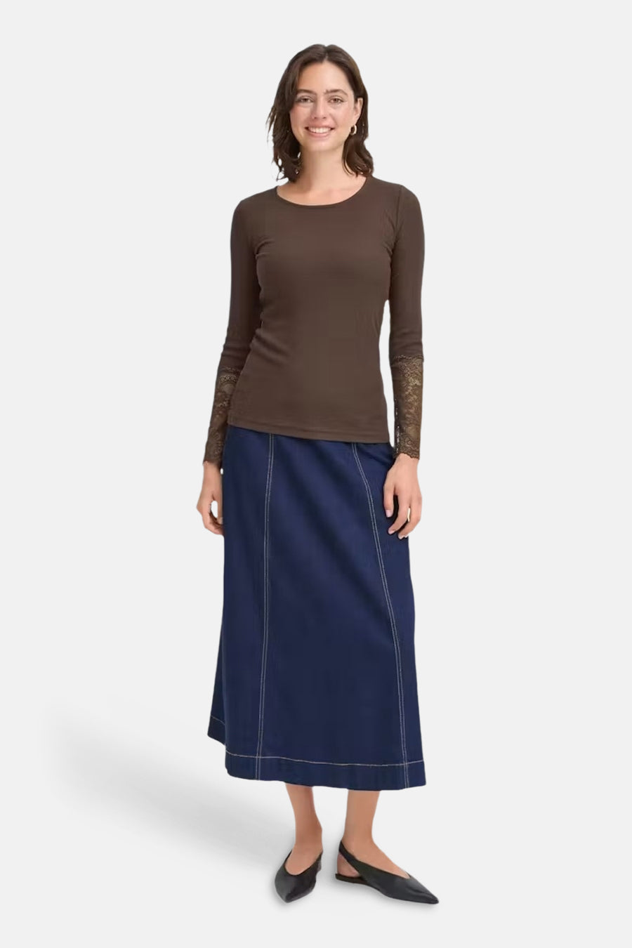 Brown long-sleeve t-shirt with lace cuffs, front view, worn with navy skirt and black flats