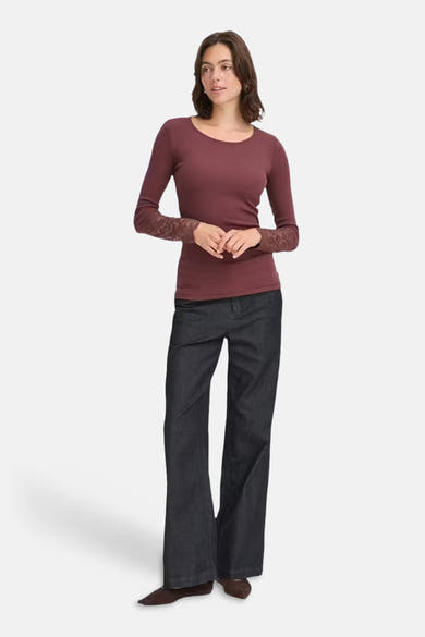 Bordeaux long-sleeve ribbed T-shirt with lace cuffs, worn with dark flared jeans and brown boots, front view