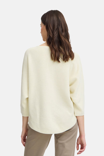 Pull à col rond écru de Fransa, vu de dos, porté avec un pantalon couleur kaki.