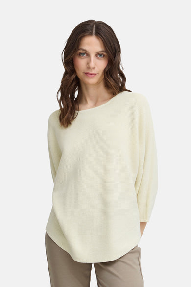 Pull écru à col rond de Fransa, avec une texture côtelée et une coupe décontractée, porté avec un pantalon beige.