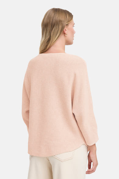 Pull à col rond rose de Fransa, avec une texture côtelée et porté avec un pantalon blanc cassé.
