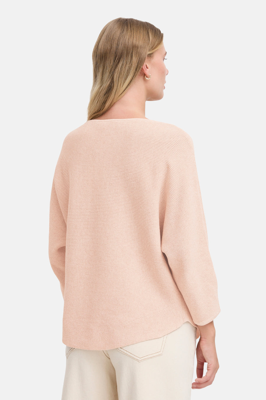 Pull à col rond rose de Fransa, avec une texture côtelée et porté avec un pantalon blanc cassé.
