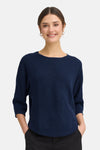 Pull à col rond bleu de Fransa, avec texture côtelée et manches trois-quarts, porté avec un pantalon noir.
