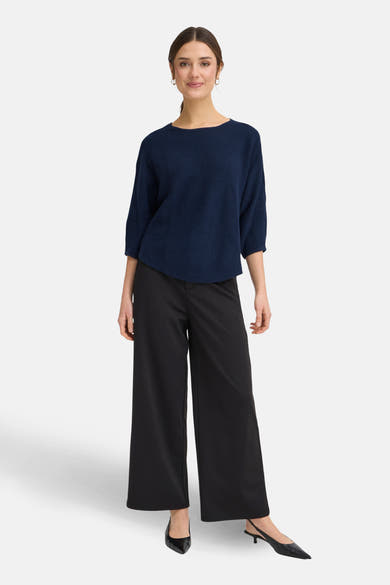 Pull à col rond bleu de Fransa, porté avec un pantalon noir ample et des escarpins noirs.