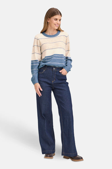 Pull à col rond multicolore de Fransa, à rayures horizontales, porté avec un jean ample et des chaussures marron.
