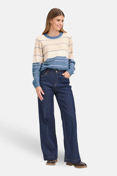 Pull à col rond multicolore de Fransa, à rayures horizontales, porté avec un jean ample et des chaussures marron.

