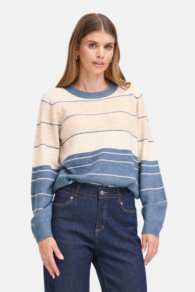 Pull à col rond multicolore de Fransa, rayures horizontales bleu et beige, porté avec un jean foncé.
