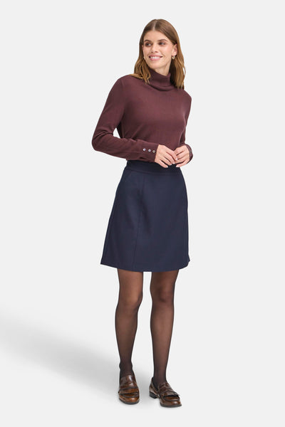 Rode coltrui van Fransa®, gedragen met een marineblauwe rok en een zwarte panty.