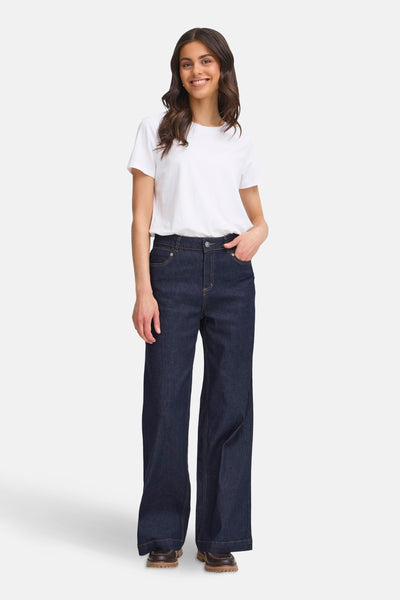 Jeans larges en denim bleu foncé par Fransa, portés avec un t-shirt blanc et des chaussures marron.