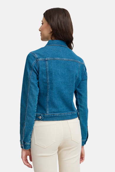 Veste en denim bleu moyen de Fransa, vue de dos, portée avec un pantalon écru.
