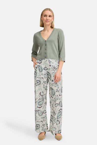 Vloeiende groene broek van Fransa, met bloemen- en paisleyprint, gedragen met een bijpassend groen vest en bruine platte schoenen.