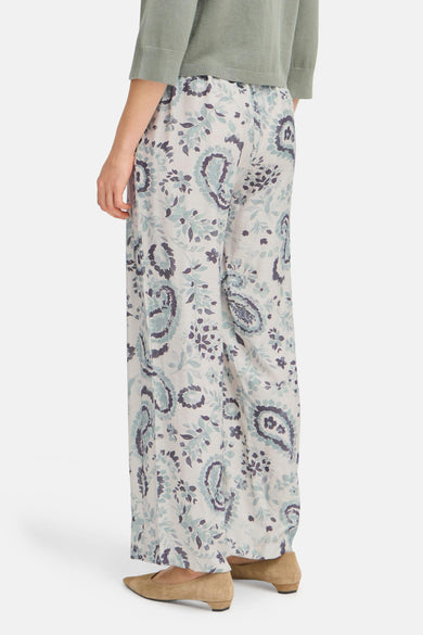 Pantalon vert à motifs de Fransa, porté avec un haut uni, et des chaussures plates en daim.