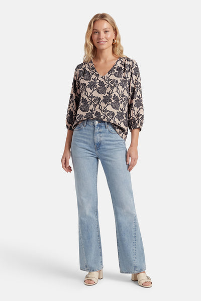 Multikleurige blouse van Fransa met zwart en beige bloemenpatroon, V-hals, 3/4 mouwen, gedragen met een spijkerbroek.
