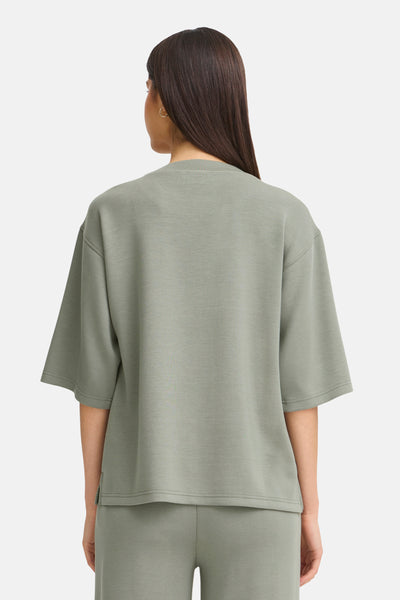 Groen sweatshirt uit Frankrijk, ronde hals, korte mouwen, gedragen met een bijpassende joggingbroek.