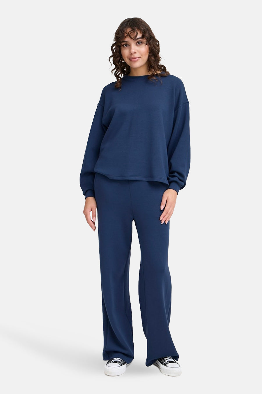 Sweat bleu de Fransa, porté avec un pantalon de détente ample et des chaussures de sport.
