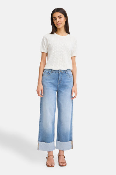 Wijde spijkerbroek in middinblauw denim van Fransa, met omslag en gedragen met een wit T-shirt en bruine sandalen.