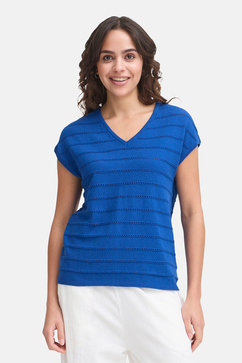 T-shirt bleu à manches courtes de Fransa, à rayures ajourées horizontales, porté avec un pantalon blanc.