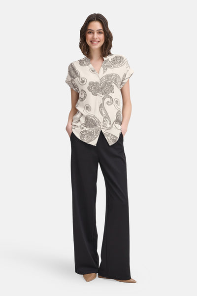 Ecru blouse met korte mouwen van Fransa®, met zwart paisley-patroon en zwarte broek met wijde pijpen.