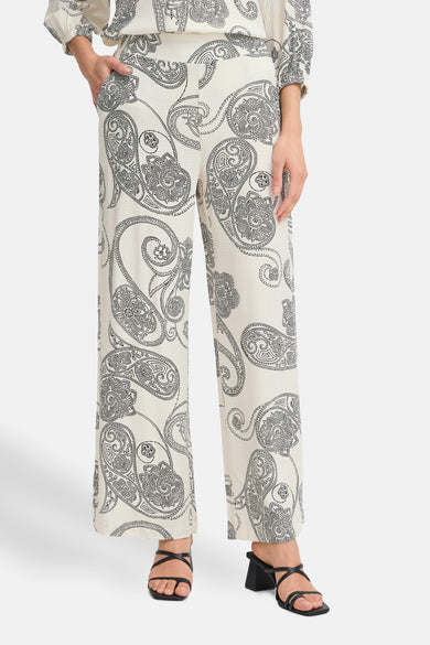 Ecru broek met paisleyprint van Fransa, losse pasvorm en wijde pijpen, gedragen met zwarte hakken.