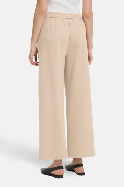 Beige kostuumbroek van Fransa, losse pasvorm en elastische taille, gedragen met een witte tanktop.