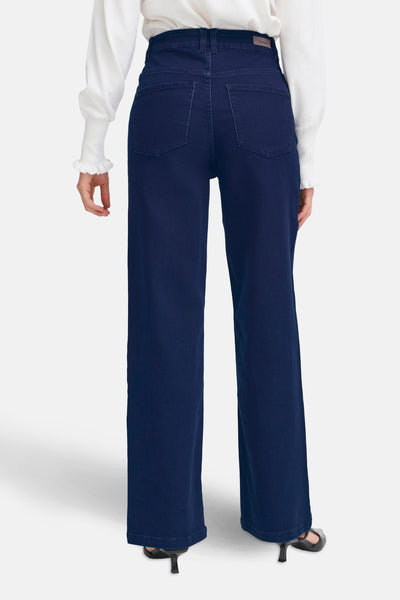 Jean large en denim bleu foncé de Fransa, vue arrière, porté avec un pull blanc.
