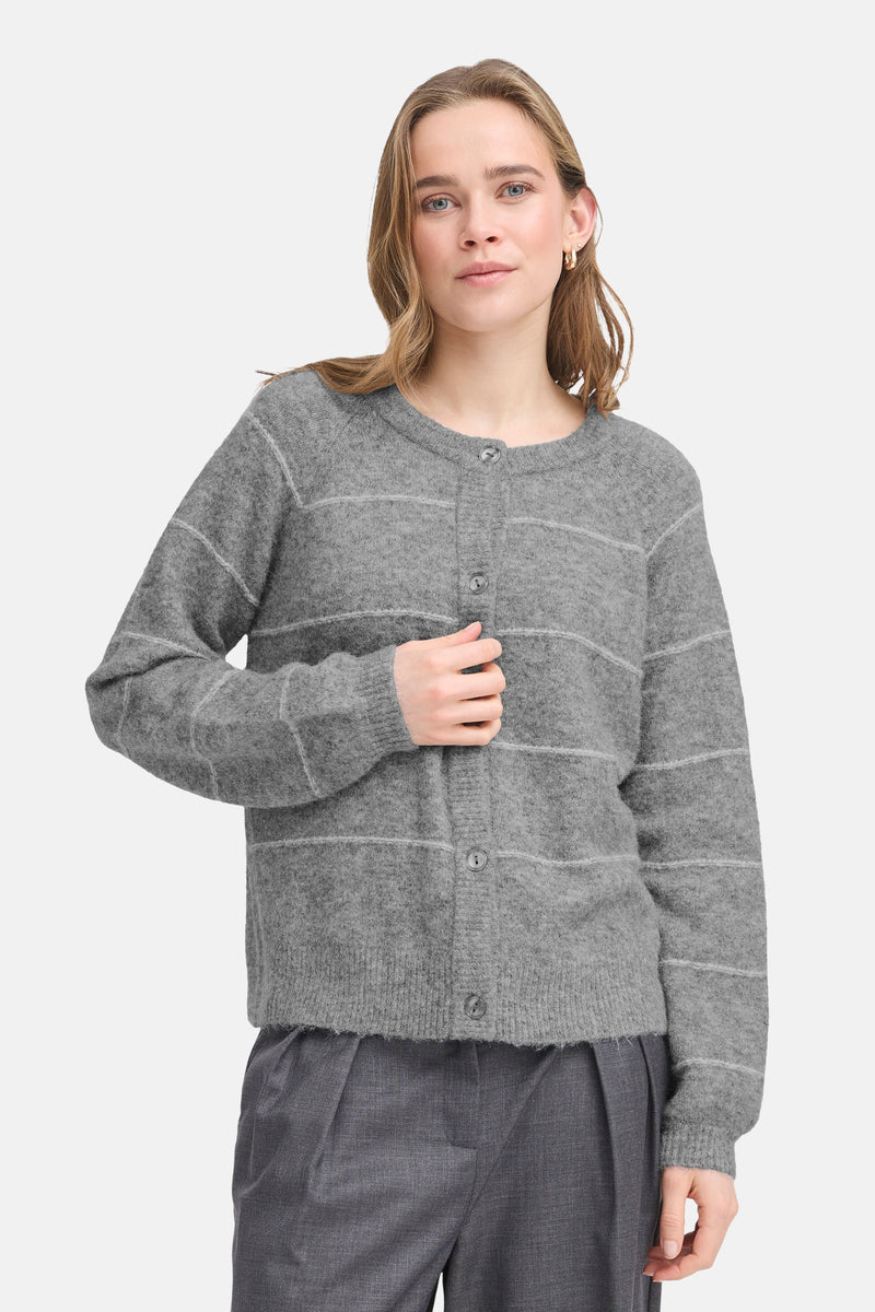Cardigan gris à rayures by Fransa, porté avec un pantalon gris à pinces et des boucles d'oreilles dorées.