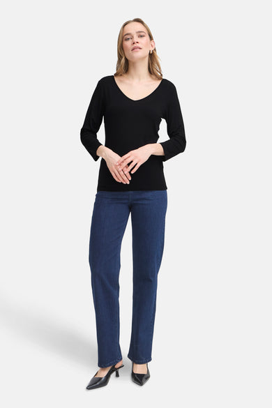 T-shirt noir à manches longues de Fransa, porté avec un jean bleu et des escarpins noirs.