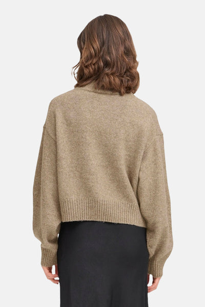 Beige coltrui van Fransa, met een gebreide textuur, gedragen over een zwarte rok.