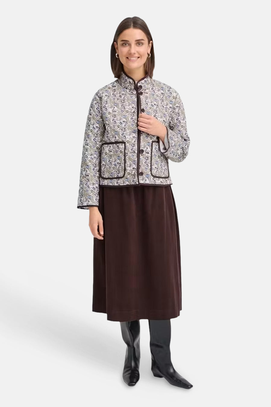 Multicolored floral-patterned casual jacket with mandarin collar and front buttons, worn over a dark brown skirt and black boots, full-length front view