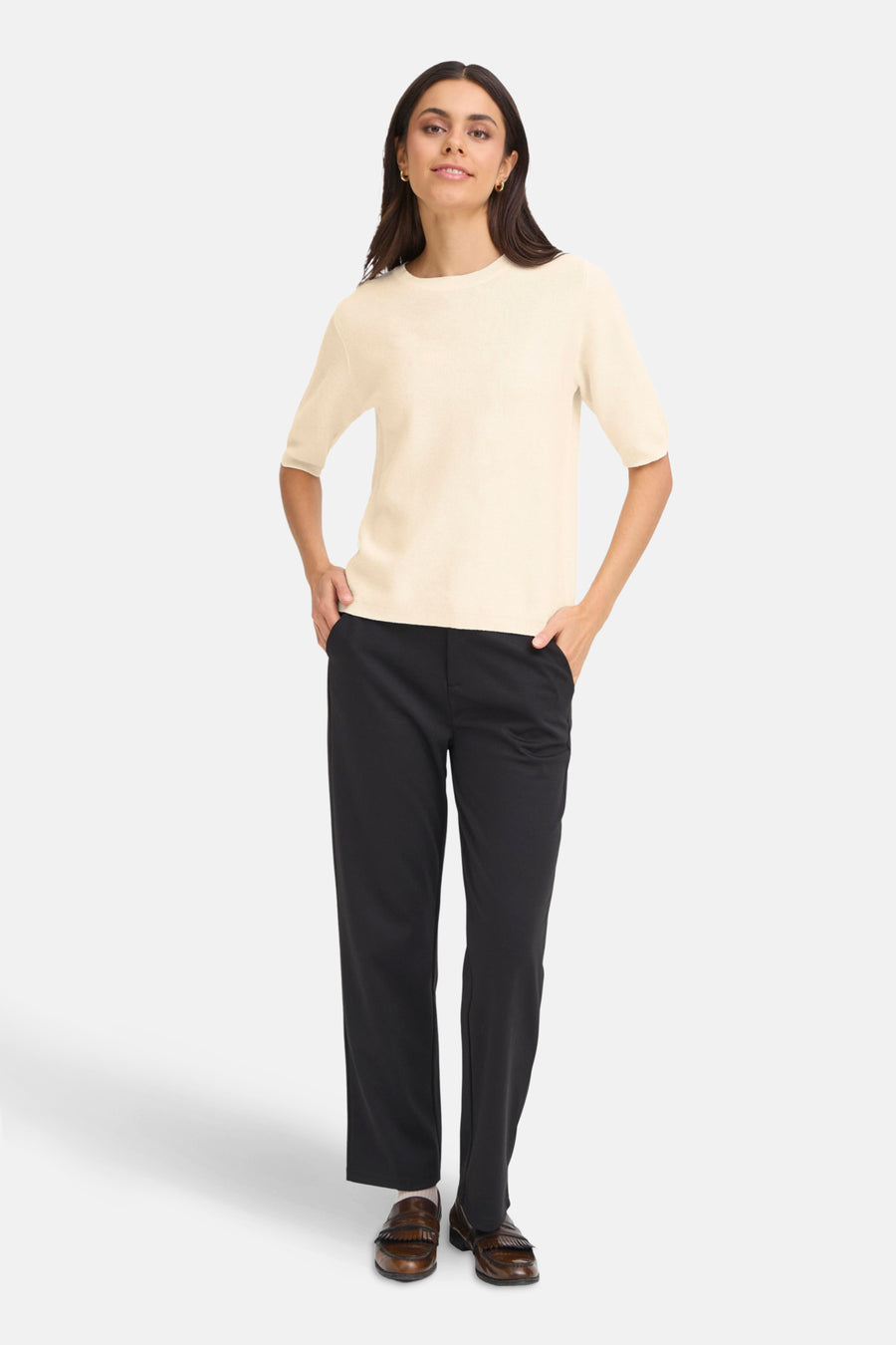 Pull à col rond beige de Fransa, porté avec un pantalon noir et des mocassins en cuir marron.