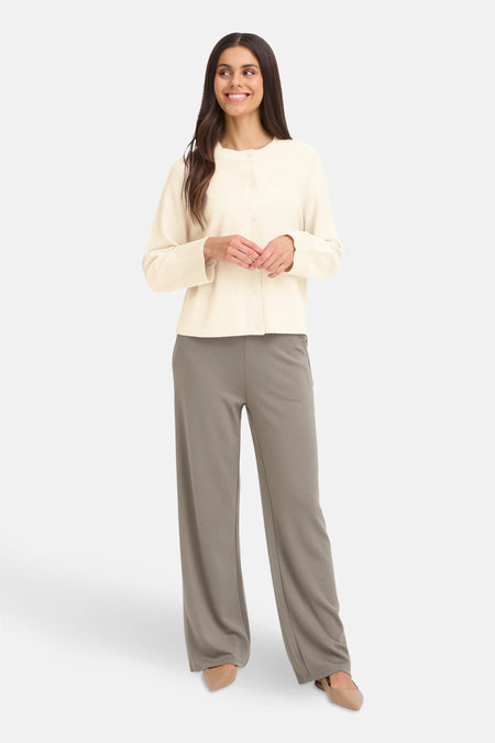 Cardigan beige de Fransa, porté avec un pantalon ample gris et des escarpins pointus en cuir.
