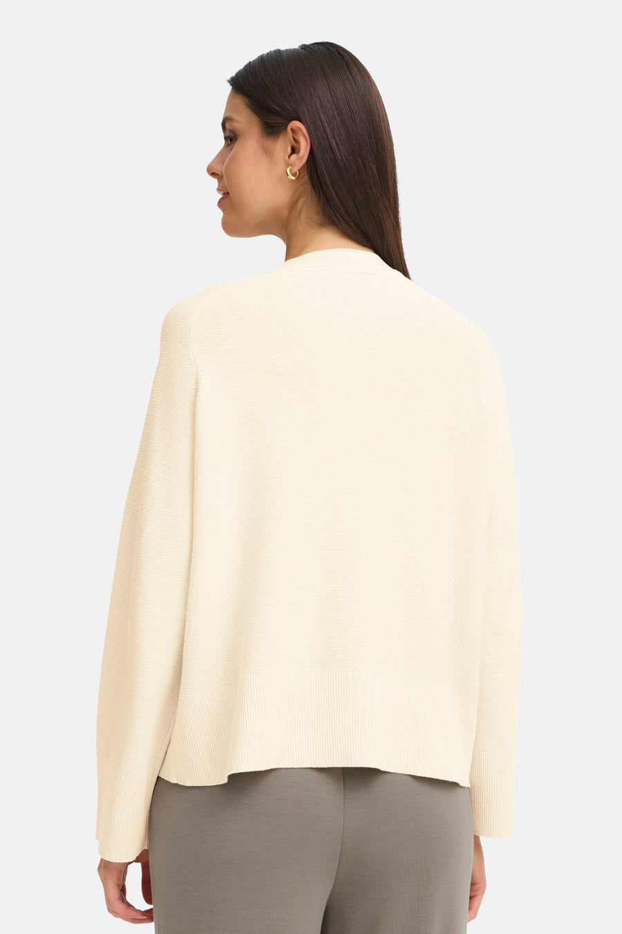 Cardigan beige, en maille texturée par Fransa, porté avec un pantalon gris uni.