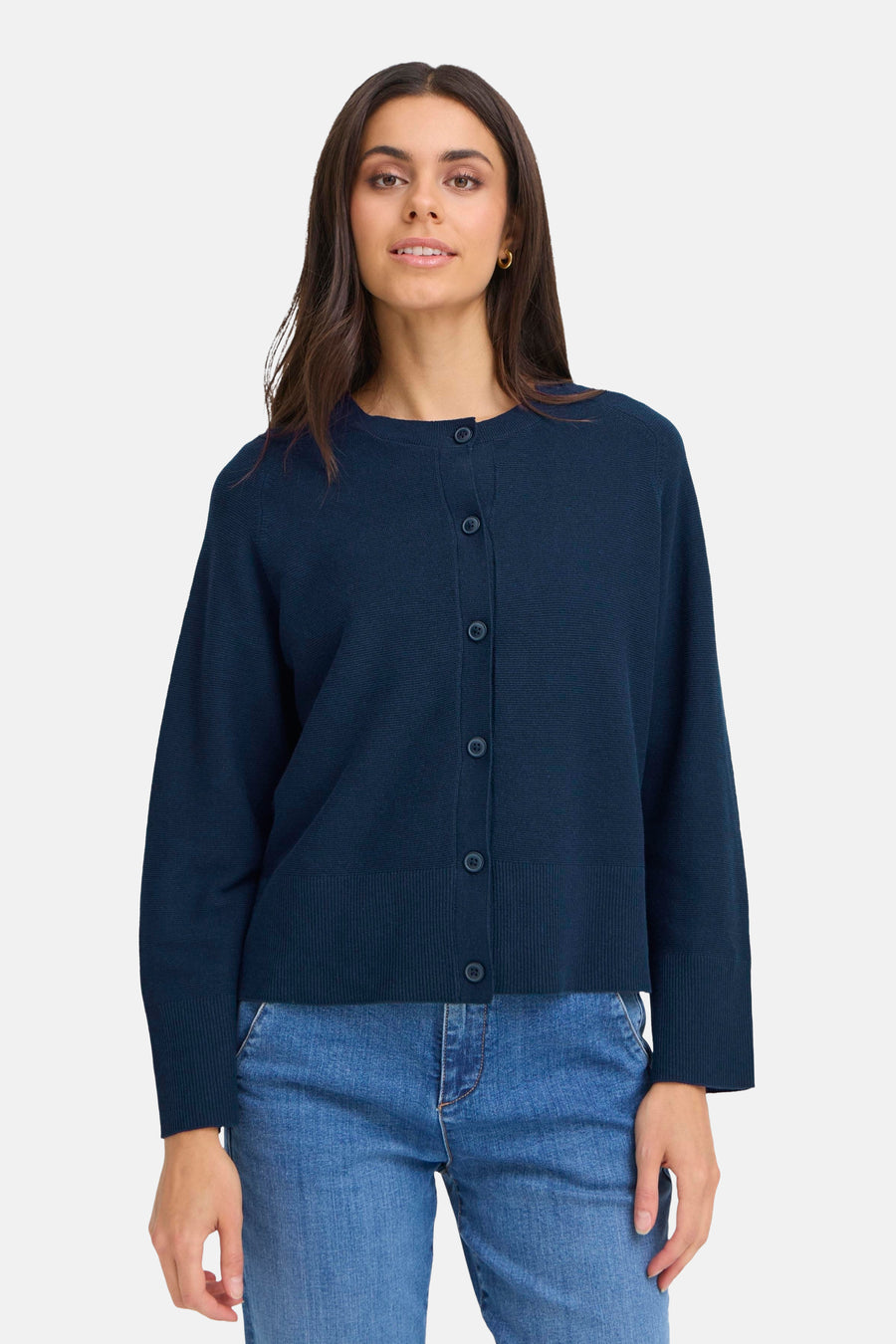Blauwe cardigan van Fransa, gedragen over een wit T-shirt en een blauwe jeans, met zwart-witte plateauzolen.