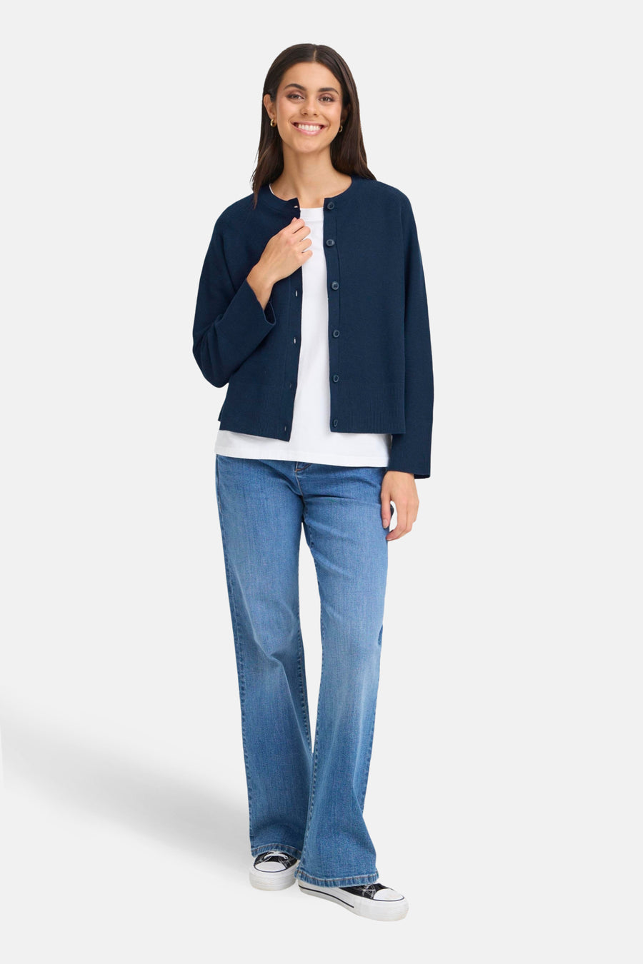 Cardigan bleu de Fransa, porté sur un t-shirt blanc et un jean bleu, avec des chaussures à plateforme noires et blanches.