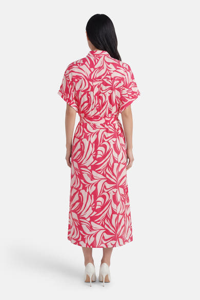 Multikleurenjurk uit Frankrijk, rood-witte bloemenprint, met bijpassende riem en witte pumps.