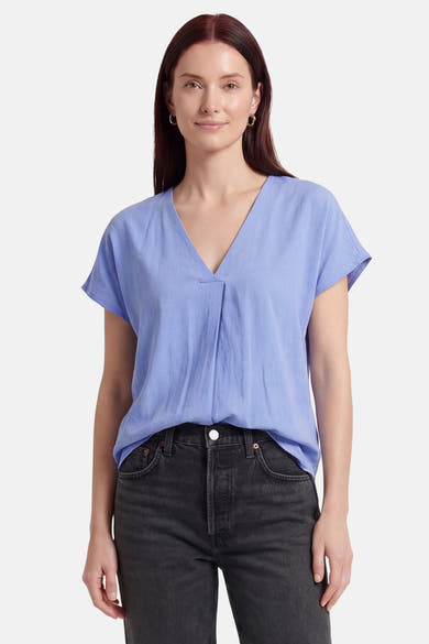 Blouse bleue à manches courtes de Fransa® avec col en V et pli frontal, portée avec un jean foncé.