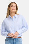 Chemisier bleu à manches longues de Fransa® avec fines rayures verticales, porté avec un jean et une ceinture marron.