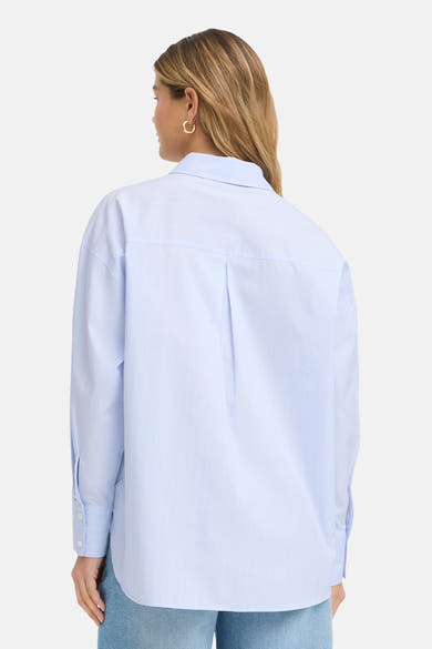 Chemisier bleu à manches longues de Fransa® à fines rayures verticales, porté de dos par une femme blonde en jean.