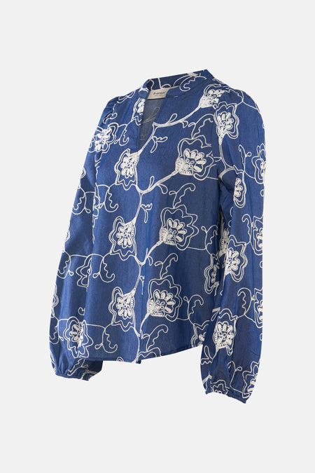 Blouse bleue à manches longues de Fransa, avec broderies florales blanches sur l'ensemble du vêtement.
