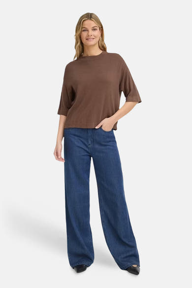 Brown O-neck sweater with relaxed fit and three-quarter sleeves, worn with wide-leg blue jeans and black shoes, front view.