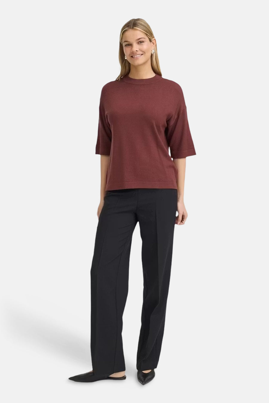 Burgundy ribbed knit round-neck pullover by Fransa, featuring three-quarter sleeves and relaxed fit, worn with black trousers and pointed flats in full-length front view.