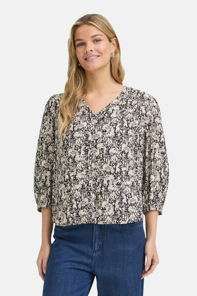 Multicolored short-sleeve blouse with floral pattern and V-neck, worn with blue jeans, front view