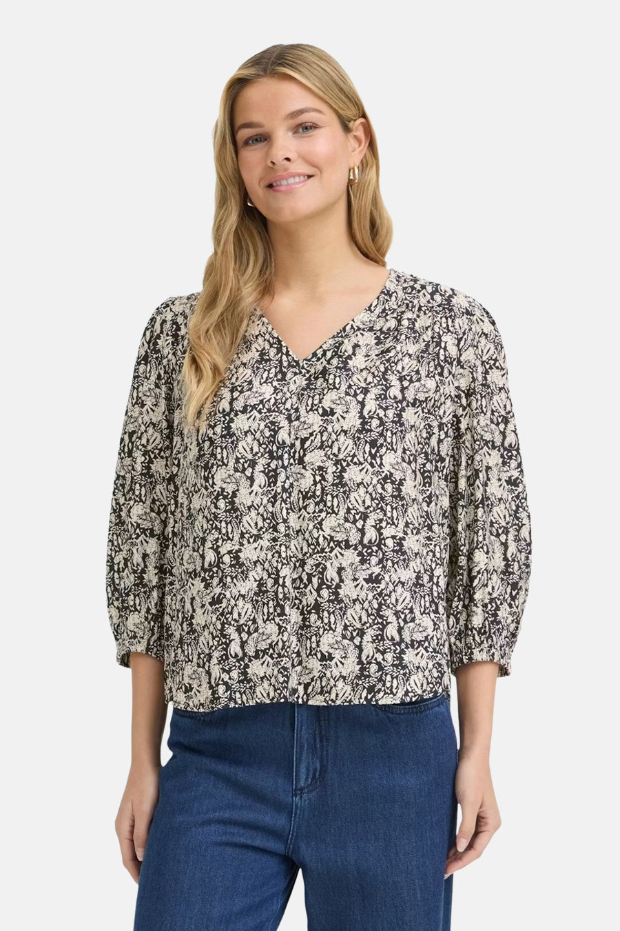Multicolored short-sleeve blouse with floral pattern and V-neck, worn with blue jeans, front view