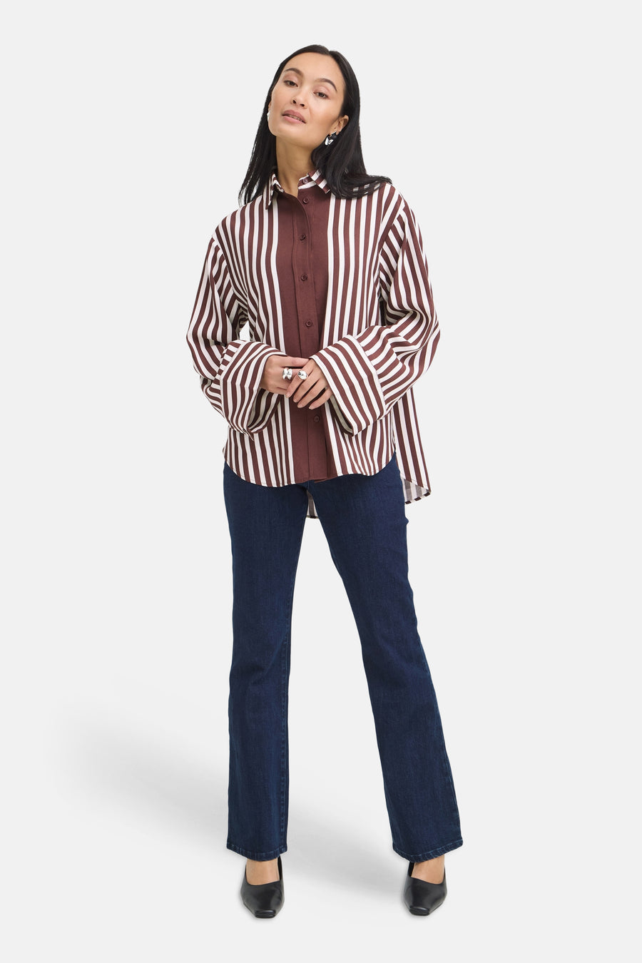 Chemise à manches longues multicolore à rayures verticales marron et blanches par Fransa®, portée avec un jean bleu foncé et des chaussures noires, vue de face.