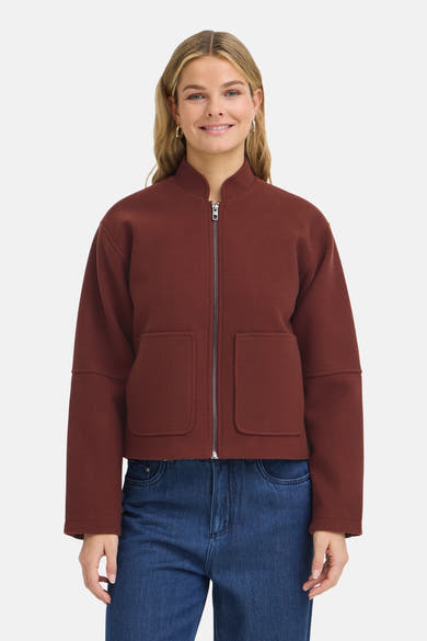 Veste courte marron par Fransa®, col montant, fermeture éclair argentée, poches avant, portée avec jeans bleus, vue de face