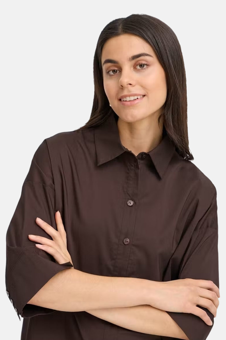 Brown long-sleeve blouse with pointed collar and button front, worn by model with arms crossed, front view