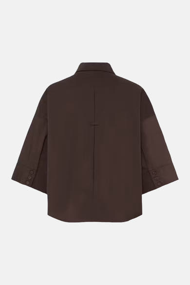 Brown long-sleeve blouse back view with central seam and buttoned cuffs, smooth fabric, minimalist design
