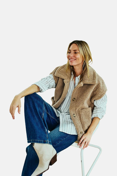 Jean large en denim bleu moyen de FREEQUENT, porté avec un gilet en peau lainée et des bottes blanches.
